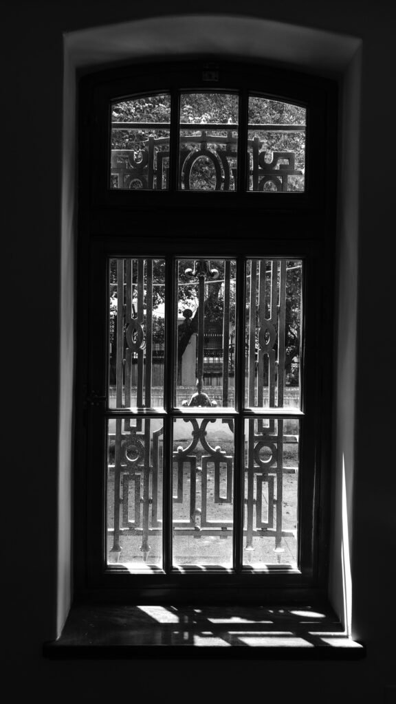 a black and white photo of a gated entrance to a building